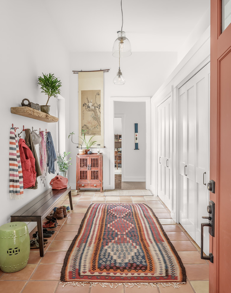 Inspiration for a transitional mudroom in Portland Maine with white walls and terra-cotta floors.