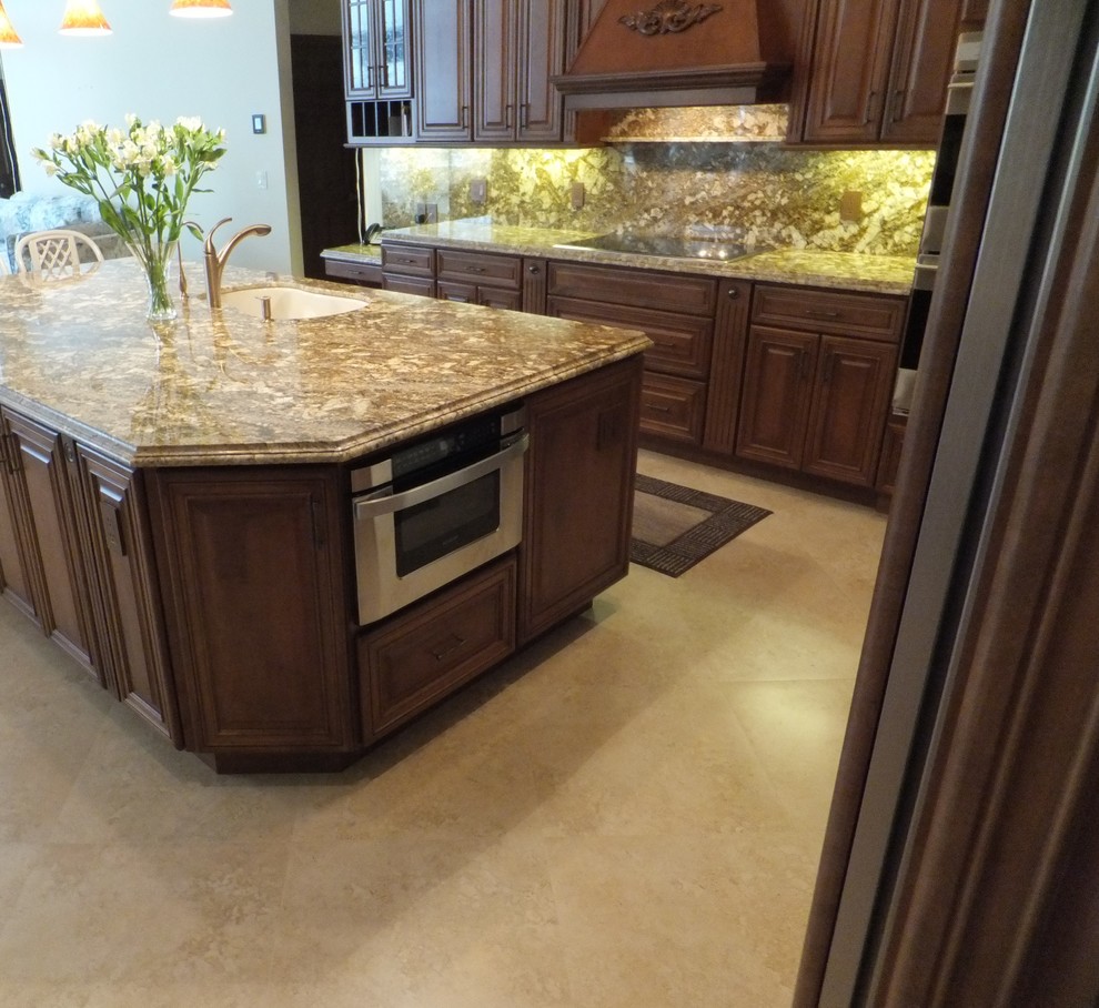 Eat-in kitchen - large transitional travertine floor eat-in kitchen idea in Miami with an undermount sink, raised-panel cabinets, medium tone wood cabinets, quartzite countertops, brown backsplash, stone slab backsplash, paneled appliances and an island