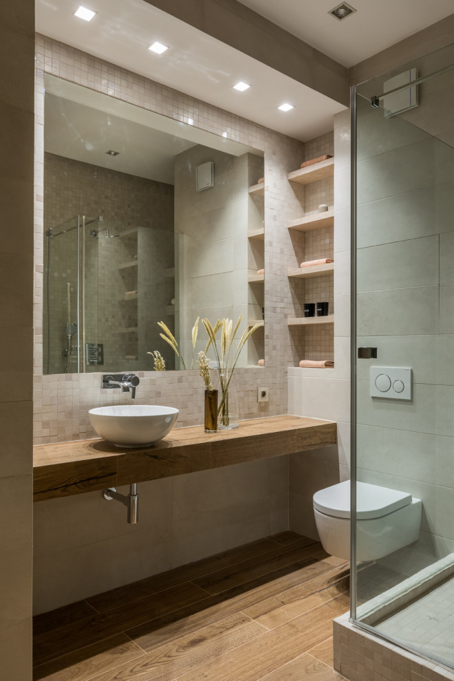 Photo of a mid-sized contemporary 3/4 bathroom in Moscow with a corner shower, a wall-mount toilet, a vessel sink, an enclosed toilet, beige tile, porcelain tile, beige walls, porcelain floors, tile benchtops, brown floor, a hinged shower door, beige benchtops, a single vanity and recessed.