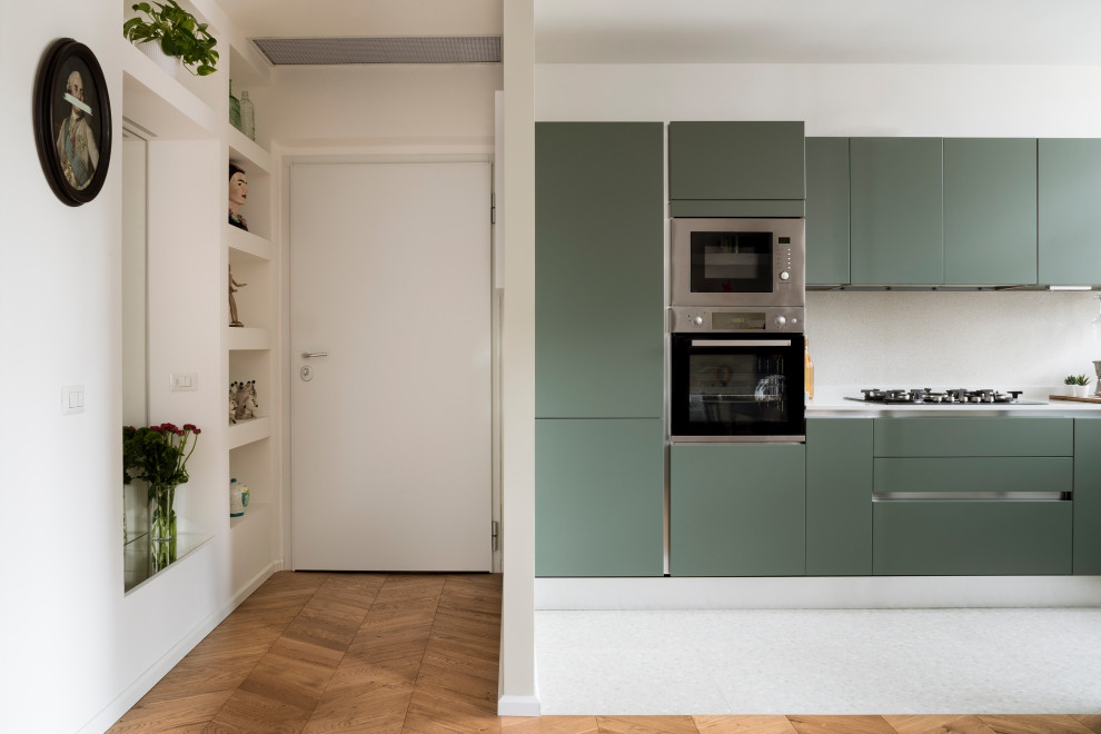 Idéer för ett avskilt modernt grå l-kök, med en enkel diskho, släta luckor, gröna skåp, granitbänkskiva, grått stänkskydd, rostfria vitvaror och grått golv