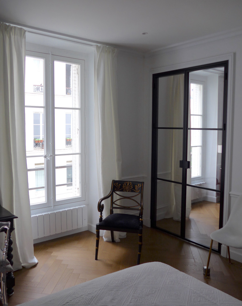 Großes Klassisches Schlafzimmer mit grüner Wandfarbe, hellem Holzboden und braunem Boden in Paris