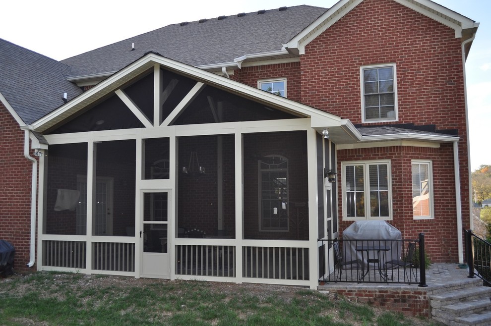 This is an example of a large traditional backyard verandah in Nashville with a fire feature, brick pavers and a roof extension.