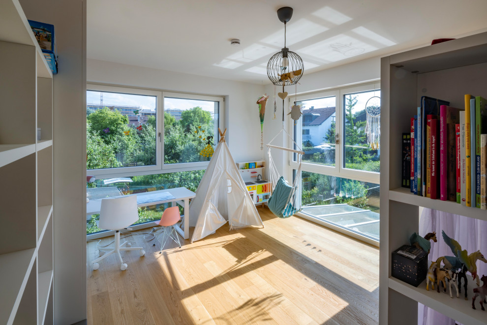Großes Modernes Kinderzimmer mit weißer Wandfarbe, braunem Holzboden und beigem Boden in München