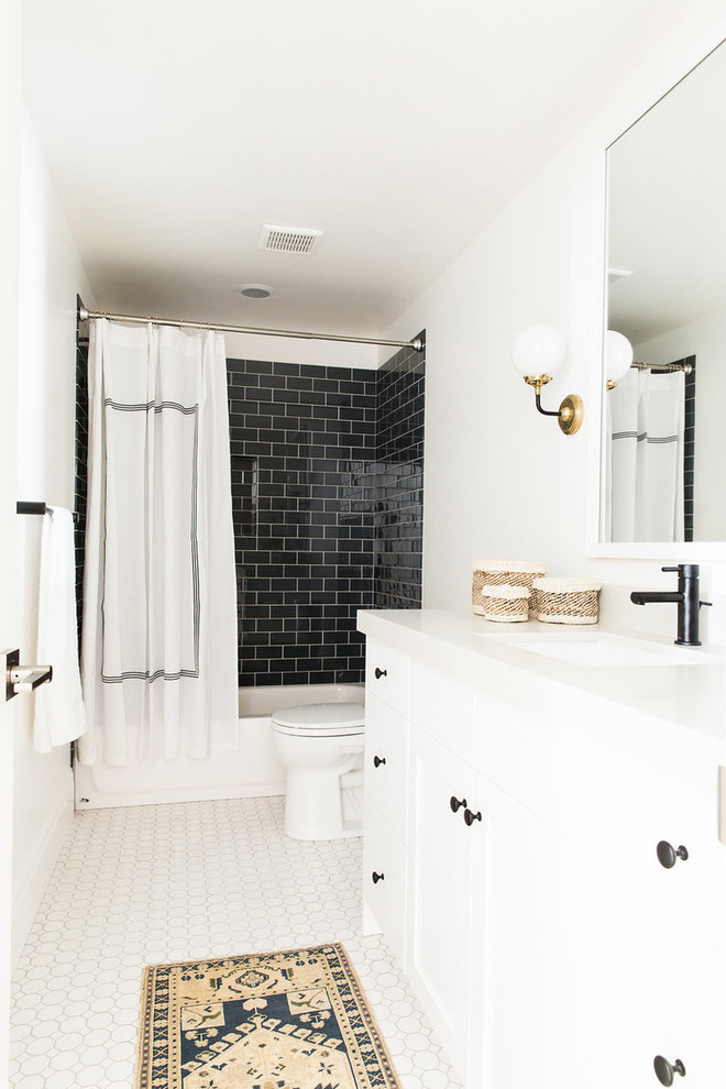 Transitional bathroom in Salt Lake City with white cabinets, a shower/bathtub combo, black tile, subway tile, white walls, an undermount sink and a shower curtain.