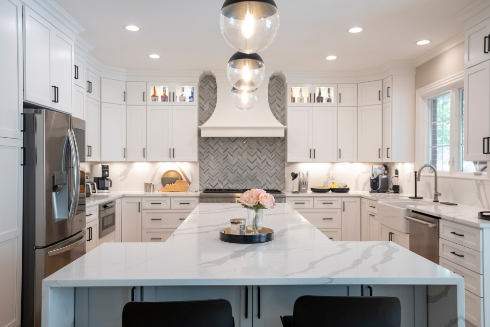 Example of a large medium tone wood floor and beige floor eat-in kitchen design with a drop-in sink, shaker cabinets, white cabinets, marble countertops, white backsplash, marble backsplash, stainless steel appliances, an island and white countertops