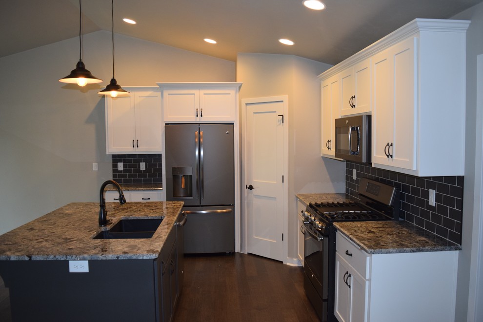 Kitchen - rustic kitchen idea with white cabinets, stainless steel appliances and an island