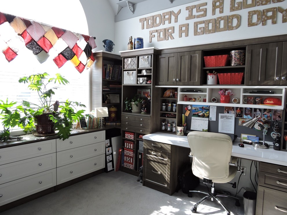 This is an example of a mid-sized craft room in Miami with white walls, carpet, a built-in desk and grey floor.