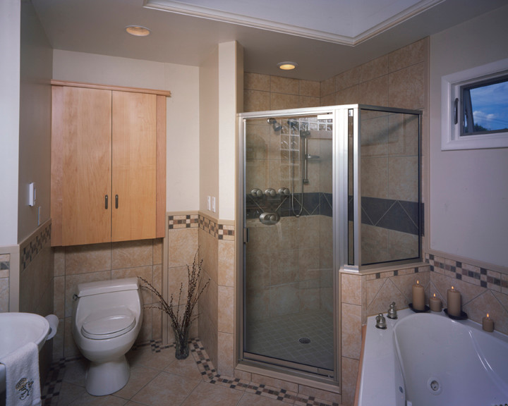Photo of a small beach style master bathroom in New York with a pedestal sink, flat-panel cabinets, light wood cabinets, a corner tub, a corner shower, a one-piece toilet, beige tile, porcelain tile, white walls and porcelain floors.