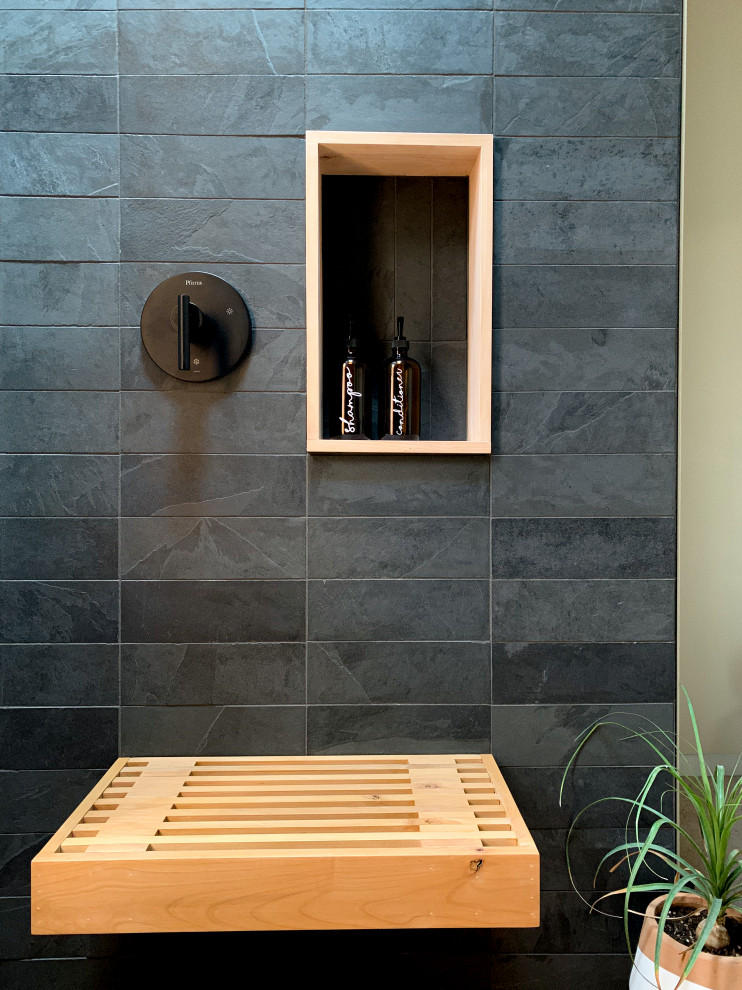 Inredning av ett modernt stort grå grått en-suite badrum, med bruna skåp, en kantlös dusch, svart kakel, skifferkakel, beige väggar, betonggolv, ett avlångt handfat, bänkskiva i betong, grått golv, med dusch som är öppen och öppna hyllor