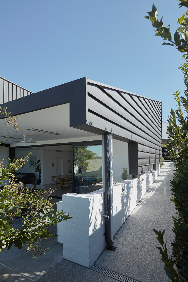 Foto de fachada de casa multicolor y negra minimalista a niveles con tejado de un solo tendido y tejado de metal
