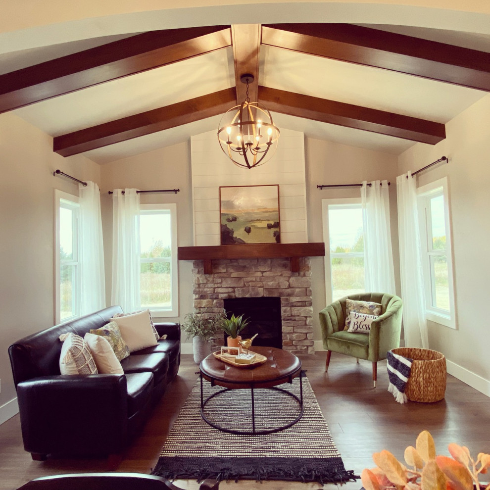 This is an example of a mid-sized country sunroom in Other with medium hardwood floors, a standard fireplace, a stone fireplace surround, a standard ceiling and brown floor.
