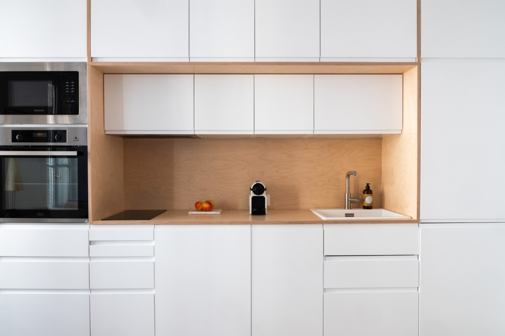Idéer för att renovera ett litet nordiskt linjärt kök med öppen planlösning, med en enkel diskho, träbänkskiva, stänkskydd i trä och rostfria vitvaror