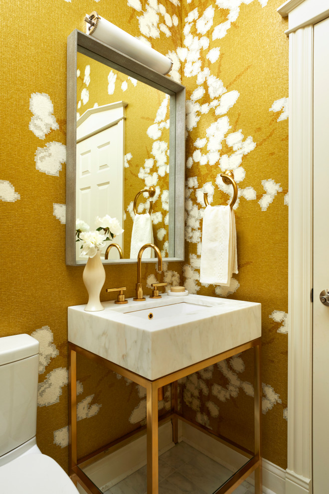 Inspiration for a small beach style powder room in Chicago with a one-piece toilet, yellow walls, marble floors, a console sink, marble benchtops, white floor and white benchtops.