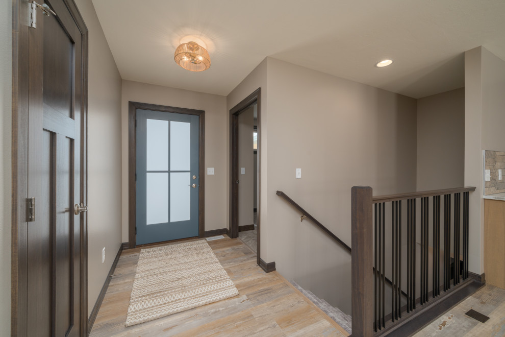 Example of a transitional vinyl floor and multicolored floor front door design with beige walls and a blue front door