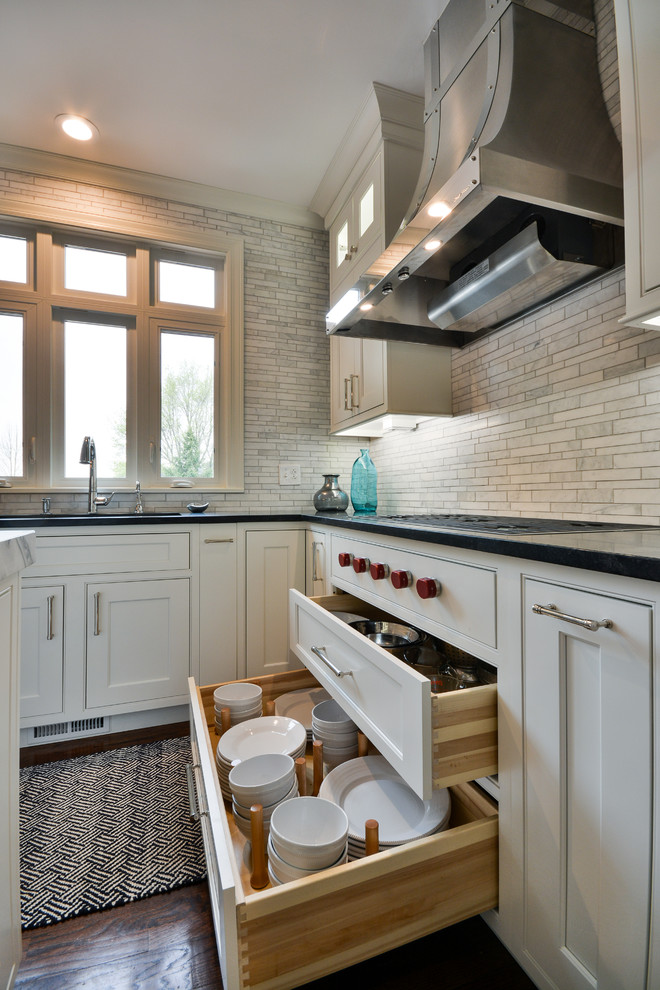 Eat-in kitchen - large transitional u-shaped dark wood floor and brown floor eat-in kitchen idea in Chicago with an undermount sink, recessed-panel cabinets, white cabinets, soapstone countertops, gray backsplash, marble backsplash, stainless steel appliances and an island