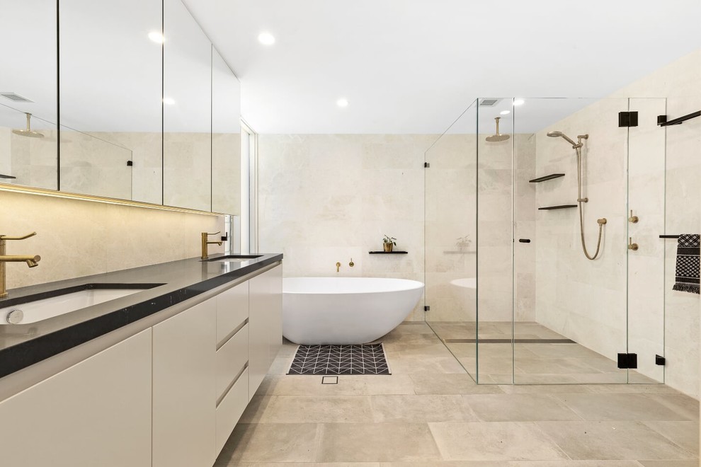 Design ideas for a mid-sized contemporary master bathroom in Sydney with flat-panel cabinets, beige cabinets, a freestanding tub, a double shower, beige tile, gray tile, beige walls, an undermount sink, grey floor, a hinged shower door and black benchtops.