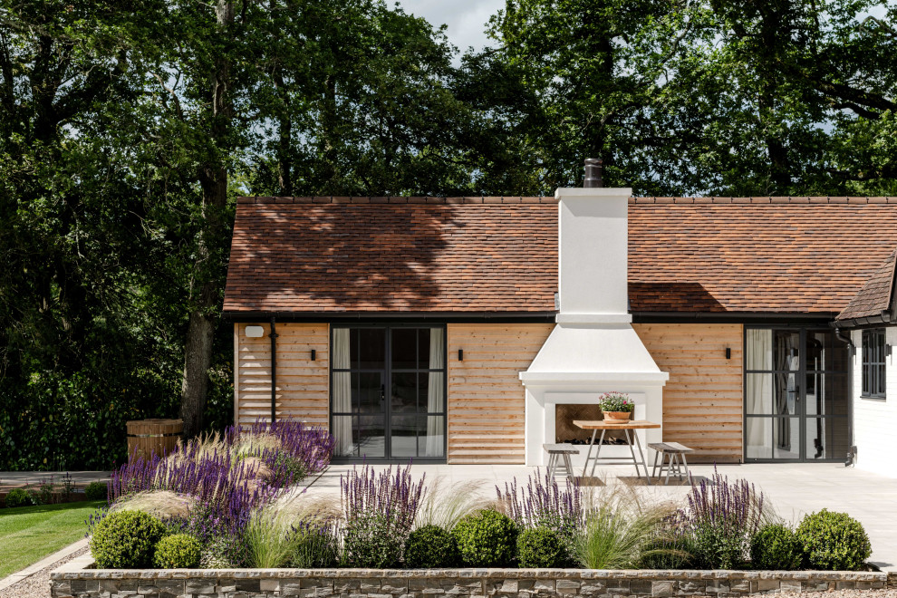 This is an example of a medium sized farmhouse patio in Sussex.