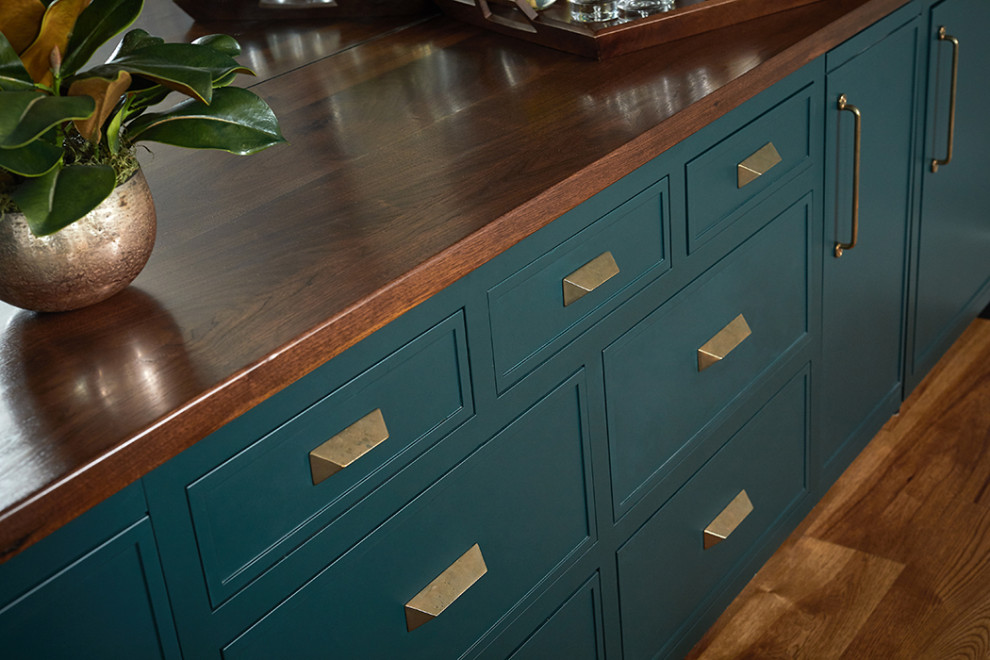Inspiration for a mid-sized transitional single-wall home bar in Grand Rapids with recessed-panel cabinets, green cabinets, wood benchtops, mirror splashback, medium hardwood floors, brown floor and brown benchtop.