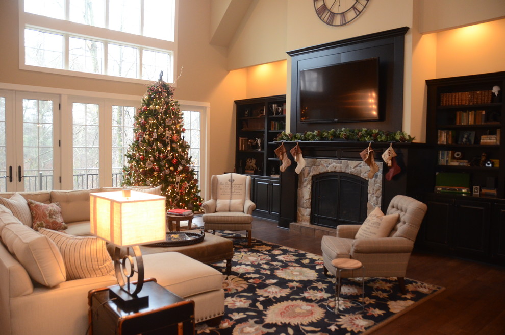 Photo of a large traditional formal open concept living room in Grand Rapids with yellow walls, medium hardwood floors, a standard fireplace, a stone fireplace surround and a wall-mounted tv.