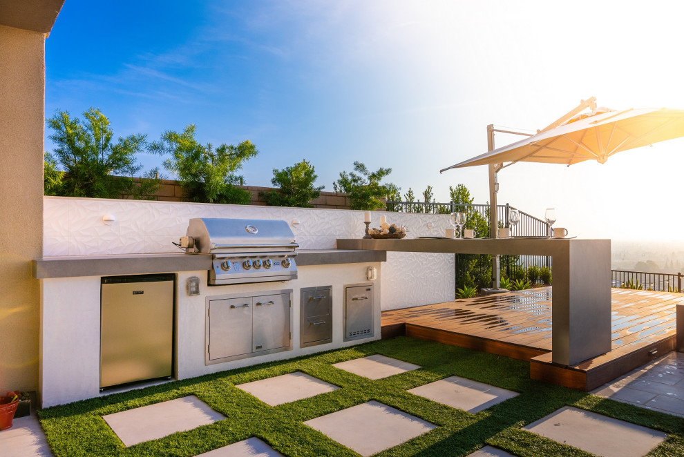 Mittelgroßer Moderner Patio hinter dem Haus mit Outdoor-Küche, Dielen und Markisen in Orange County
