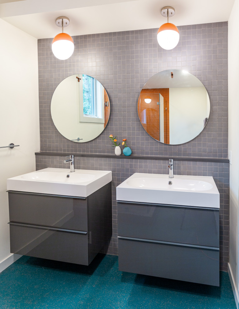 This is an example of a mid-sized midcentury master bathroom in Detroit with flat-panel cabinets, grey cabinets, a corner shower, a one-piece toilet, gray tile, ceramic tile, white walls, an integrated sink, solid surface benchtops, turquoise floor, a hinged shower door, turquoise benchtops, a double vanity, a floating vanity and vaulted.