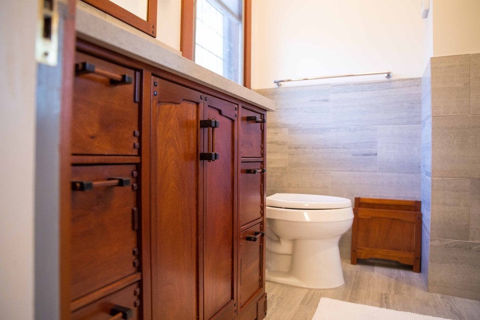 Small transitional master bathroom in New York with recessed-panel cabinets, medium wood cabinets, a corner shower, a two-piece toilet, beige tile, marble, white walls, limestone floors, an undermount sink and marble benchtops.