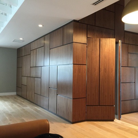 Photo of a large modern entryway in Miami with brown walls, light hardwood floors, a pivot front door and a blue front door.