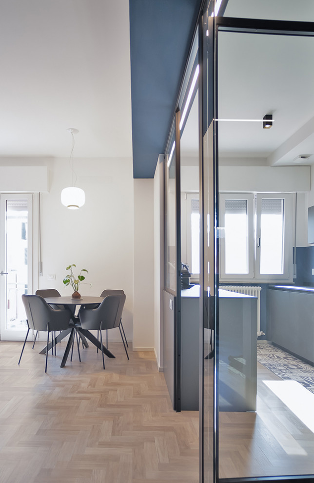 Diseño de salón abierto contemporáneo de tamaño medio con paredes azules, suelo de madera clara y suelo gris