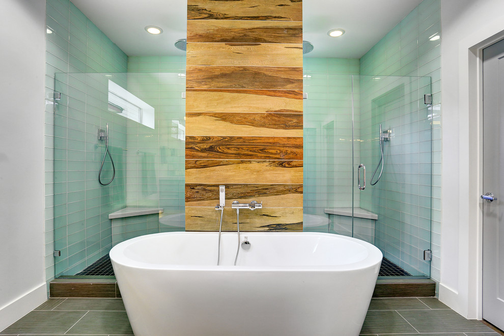 Inspiration for a large contemporary master bathroom in Houston with a drop-in sink, recessed-panel cabinets, grey cabinets, glass benchtops, a freestanding tub, a double shower, a one-piece toilet, green tile, glass tile, white walls and ceramic floors.