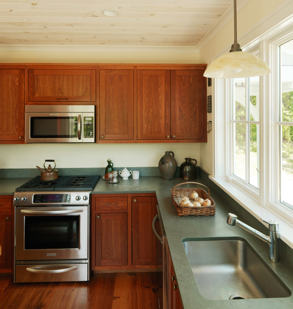 Inspiration for a mid-sized cottage l-shaped medium tone wood floor eat-in kitchen remodel in Burlington with an undermount sink, shaker cabinets, dark wood cabinets, granite countertops, green backsplash, stone slab backsplash, stainless steel appliances and an island