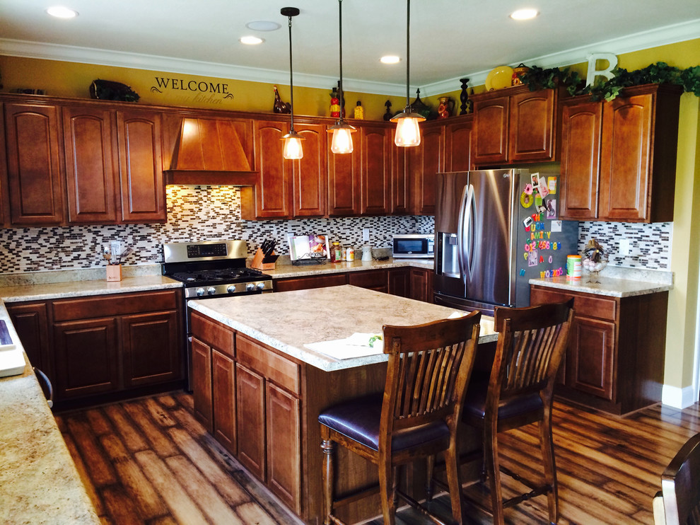 Mountain style u-shaped eat-in kitchen photo in Indianapolis with distressed cabinets, stainless steel appliances and an island