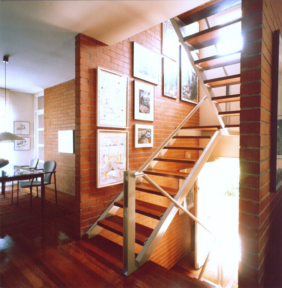 Example of a mid-sized minimalist wooden open, metal railing and brick wall staircase design in Madrid
