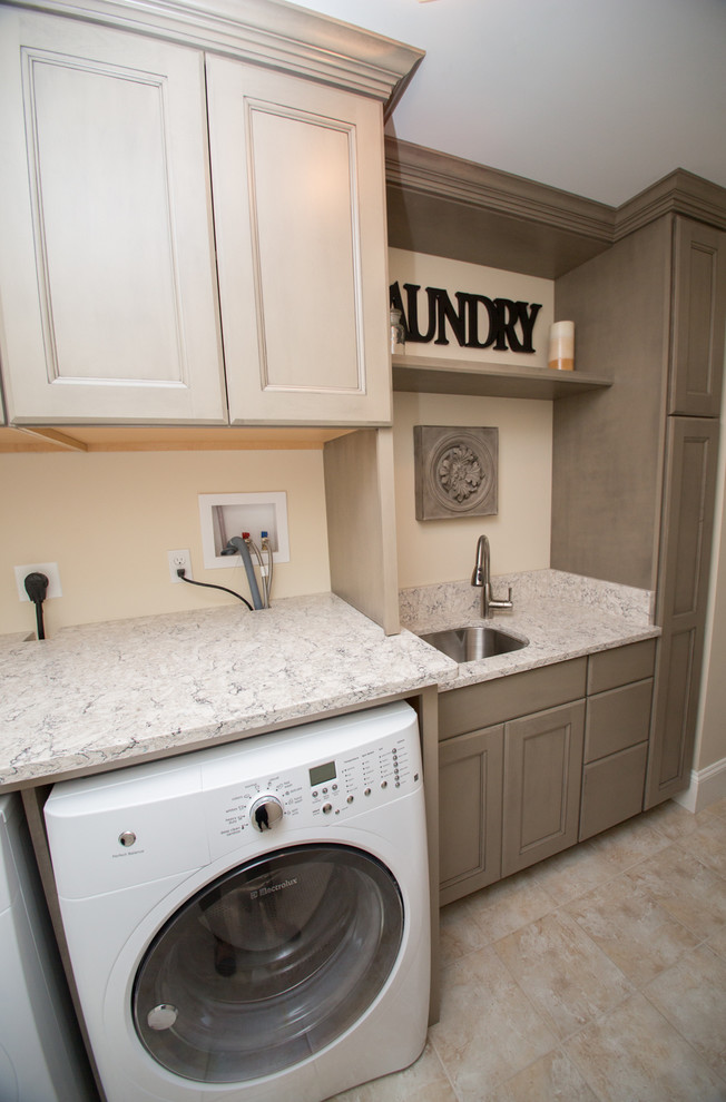 Inspiration for a mid-sized transitional single-wall dedicated laundry room in Boston with an undermount sink, a side-by-side washer and dryer, recessed-panel cabinets, beige cabinets, granite benchtops, beige walls, ceramic floors, beige floor and grey benchtop.