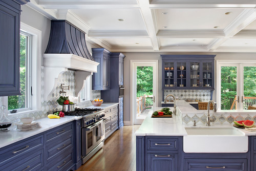 Two-tone kitchen cabinets in Canada: crisp white accents with navy blue cabinetry, white quartz countertops, patterned tile backsplash, and farmhouse sink—classic, fresh contrast