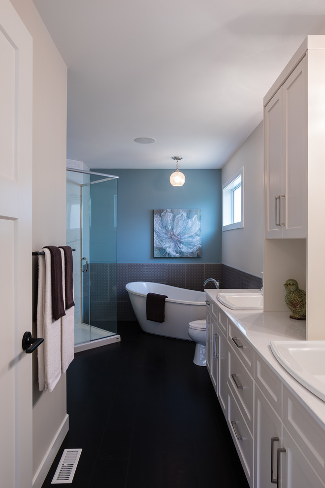 Inspiration for a mid-sized traditional master bathroom in Other with shaker cabinets, white cabinets, a freestanding tub, a corner shower, a two-piece toilet, gray tile, ceramic tile, blue walls, cork floors, a drop-in sink, engineered quartz benchtops, brown floor, a hinged shower door and white benchtops.