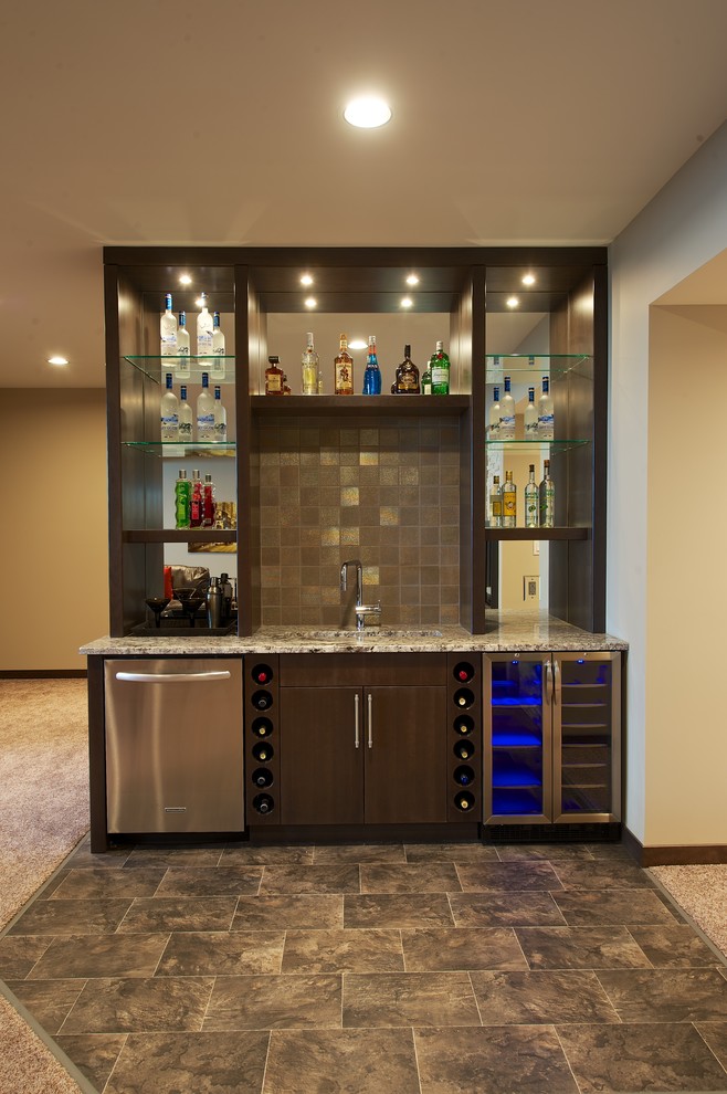 Inspiration for a mid-sized traditional single-wall wet bar in Other with an undermount sink, flat-panel cabinets, dark wood cabinets, granite benchtops, brown splashback, stone tile splashback and ceramic floors.