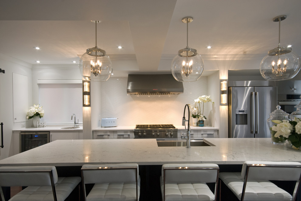 Mid-sized transitional galley medium tone wood floor and brown floor eat-in kitchen photo with a farmhouse sink, glass-front cabinets, white cabinets, quartz countertops, white backsplash, ceramic backsplash, stainless steel appliances, an island and white countertops