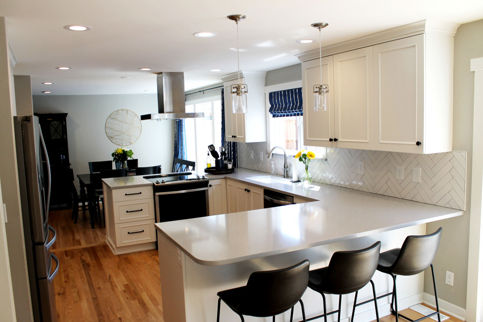 Mid-sized transitional u-shaped medium tone wood floor eat-in kitchen photo in Seattle with an undermount sink, shaker cabinets, white cabinets, quartz countertops, white backsplash, ceramic backsplash, stainless steel appliances, a peninsula and gray countertops