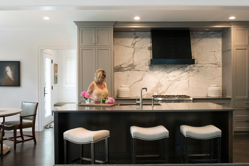 Open concept kitchen - large transitional l-shaped dark wood floor and brown floor open concept kitchen idea in Minneapolis with an undermount sink, shaker cabinets, gray cabinets, marble backsplash, stainless steel appliances, an island, quartzite countertops and white backsplash