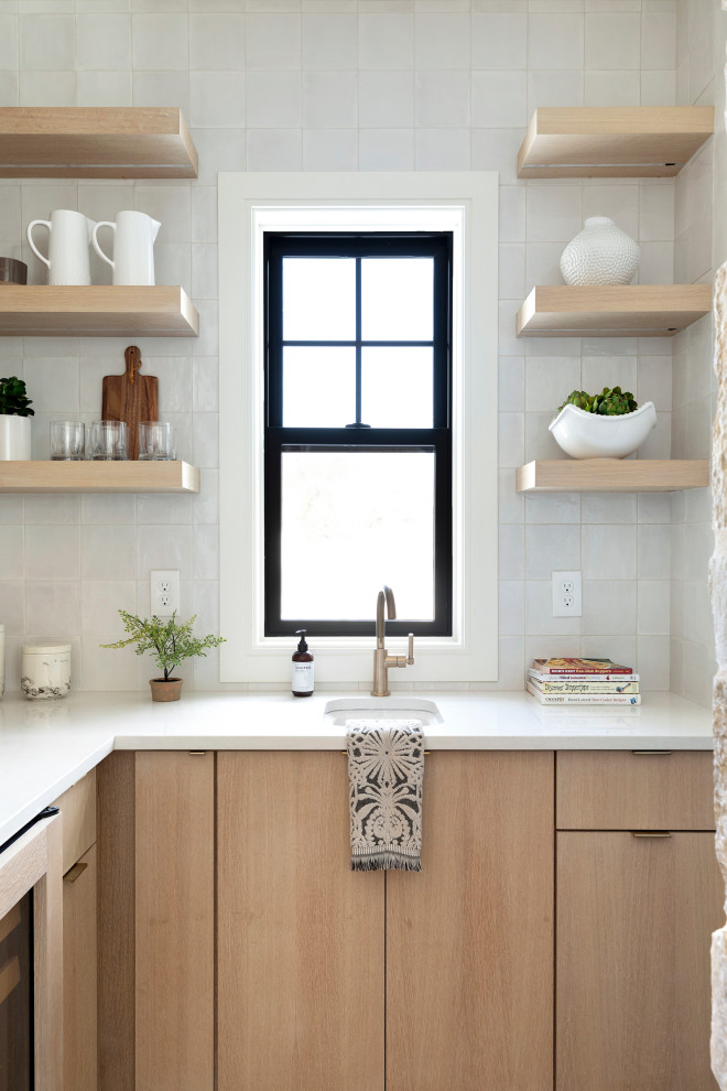 Photo of a scandinavian kitchen pantry in Minneapolis with light wood cabinets, quartzite benchtops, stainless steel appliances, light hardwood floors and white benchtop.