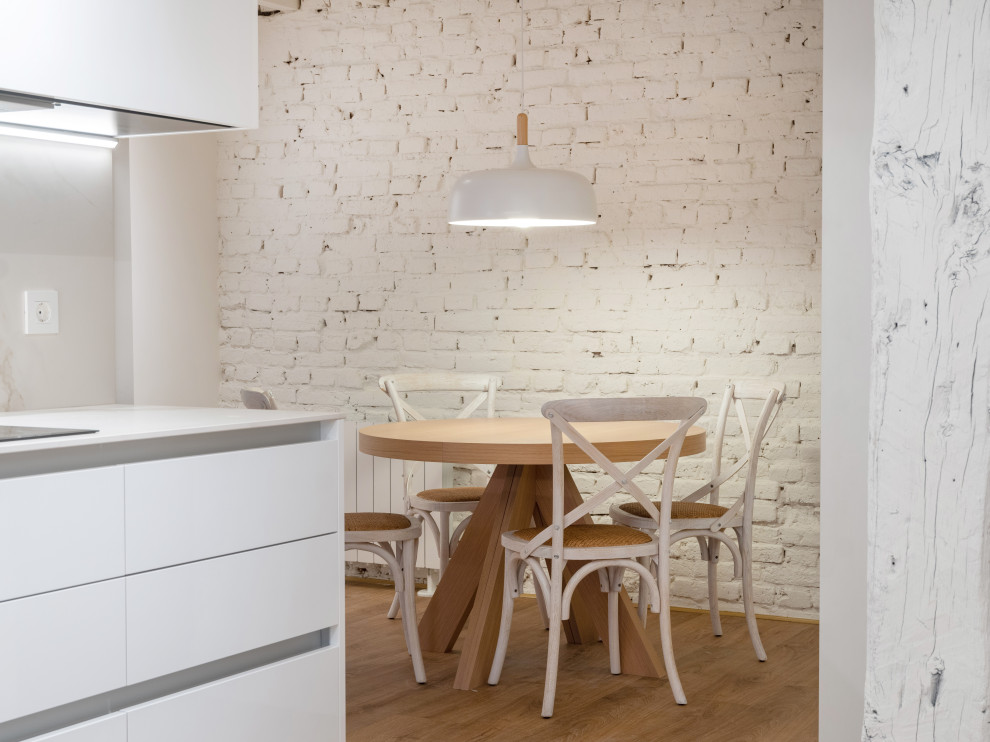 Foto de comedor de cocina tradicional renovado con paredes blancas, suelo vinílico, suelo beige, vigas vistas y ladrillo