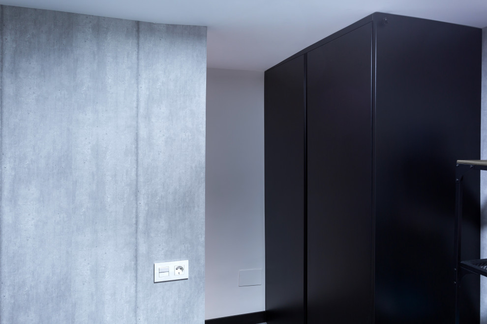 Diseño de armario vestidor unisex industrial pequeño con puertas de armario negras, suelo de baldosas de porcelana y suelo gris