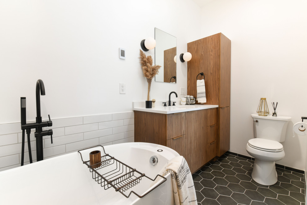 Photo of a small midcentury master bathroom in Chicago with flat-panel cabinets, medium wood cabinets, a freestanding tub, a corner shower, a one-piece toilet, white tile, subway tile, white walls, porcelain floors, an undermount sink, quartzite benchtops, black floor, a hinged shower door, white benchtops, a single vanity and a built-in vanity.