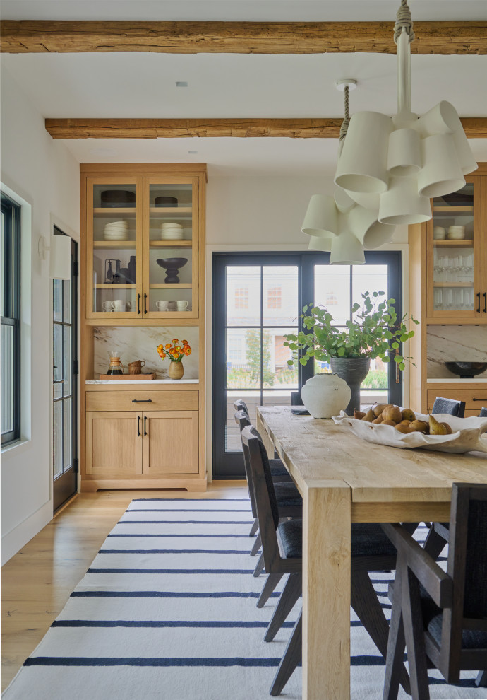 Example of a beach style medium tone wood floor, brown floor and exposed beam dining room design in Boston with beige walls