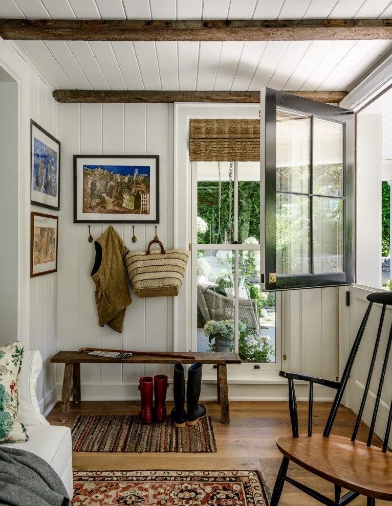 This is an example of a traditional mudroom in Seattle with white walls, medium hardwood floors, a dutch front door, a white front door, brown floor, exposed beam and planked wall panelling.