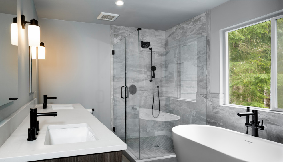 Photo of a mid-sized contemporary master bathroom in Seattle with shaker cabinets, grey cabinets, a freestanding tub, a corner shower, gray tile, porcelain tile, grey walls, porcelain floors, an undermount sink, engineered quartz benchtops, grey floor, a hinged shower door, white benchtops, a niche, a double vanity and a built-in vanity.