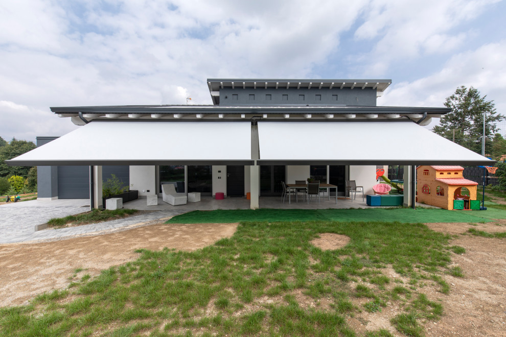Inspiration for a large modern back full sun garden in Milan with natural stone paving.
