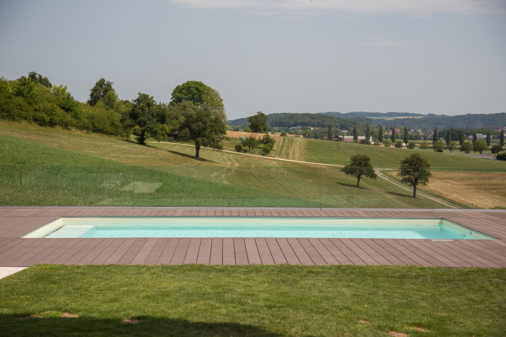 Immagine di una grande piscina a sfioro infinito minimalista rettangolare con piastrelle
