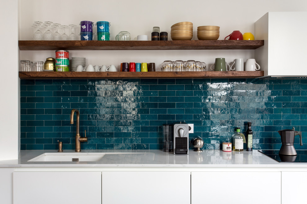 This is an example of a mid-sized midcentury single-wall open plan kitchen in Paris with white cabinets, marble benchtops, blue splashback, ceramic splashback, cement tiles, with island, blue floor and white benchtop.