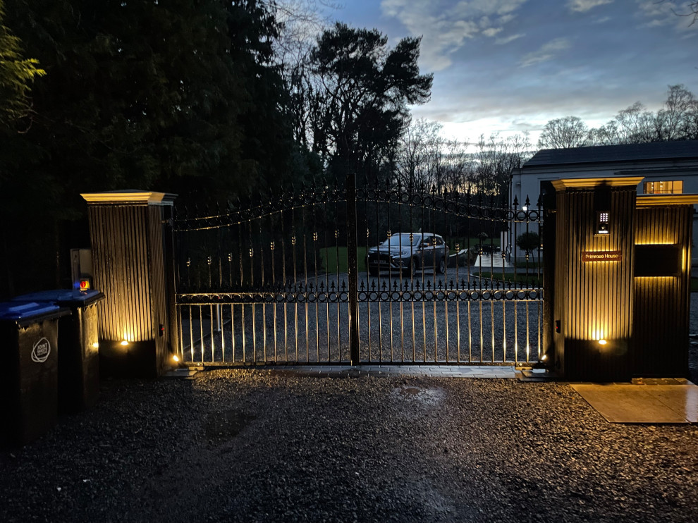 Photo of a large traditional front yard partial sun driveway for winter in Surrey with with a gate, brick pavers and a wood fence.